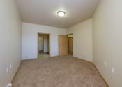 Thumbnail 28 of 61 - A spacious bedroom with carpet and a door to a hallway. West Fargo, ND West Lake Apartments.