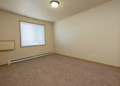 Thumbnail 20 of 61 - An empty bedroom with carpet and a window. West Fargo, ND West Lake Apartments.