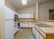 Thumbnail 19 of 61 - Akitchen with white cabinets and a sink and a refrigerator. West Fargo, ND West Lake Apartments.