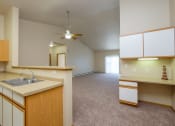 Thumbnail 18 of 61 - An empty kitchen and living room with a ceiling fan. West Fargo, ND West Lake Apartments.