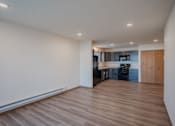 Thumbnail 34 of 49 - an empty living room and kitchen with wood floors and white walls. Fargo, ND Lake Crest Apartments