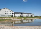 Thumbnail 61 of 61 - A large building with a pond in front of it. Fargo, ND West Lake Apartments.