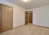 Thumbnail 6 of 11 - a bedroom with a door to the hallway and a closet. Fargo, ND Westcourt Apartments