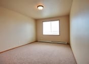 Thumbnail 23 of 61 - a bedroom with a window and a carpeted floor. West Fargo, ND West Lake Apartments.