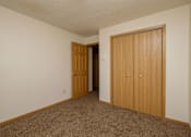 Thumbnail 8 of 9 - A bedroom with a closet. Fargo, ND Windgate Apartments.