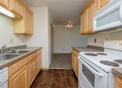 Thumbnail 7 of 9 - A kitchen with white appliances. Fargo, ND Windgate Apartments.