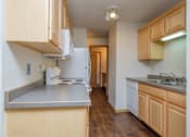 Thumbnail 6 of 9 - A kitchen with white appliances. Fargo, ND Windgate Apartments.