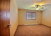 Thumbnail 19 of 21 - a bedroom with a window and a carpeted floor. Fargo, ND Wolf Creek Apartments
