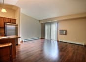Thumbnail 15 of 21 - a living room with a glass sliding door and wood floors. Fargo, ND Wolf Creek Apartments