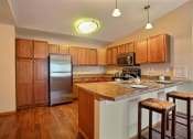 Thumbnail 12 of 21 - a kitchen with stainless steel appliances and wooden cabinets. Fargo, ND Wolf Creek Apartments