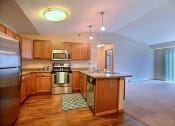 Thumbnail 11 of 21 - a kitchen with stainless steel appliances and wooden cabinets. Fargo, ND Wolf Creek Apartments