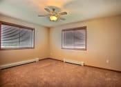 Thumbnail 13 of 21 - a bedroom with two windows and a carpeted floor. Fargo, ND Wolf Creek Apartments