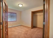 Thumbnail 9 of 21 - a bedroom with a closet and window. Fargo, ND Wolf Creek Apartments