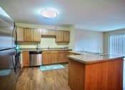 Thumbnail 6 of 21 - a kitchen with stainless steel appliances and wooden cabinets. Fargo, ND Wolf Creek Apartments