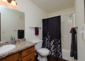 Thumbnail 11 of 11 - a bathroom with a shower toilet and sink. Moorhead, MN Woodstone Apartments