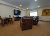 Thumbnail 23 of 23 - an open community room with leather furniture and a television. Fargo, ND North Sky Apartments