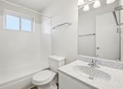 Thumbnail 11 of 23 - A white bathroom with a toilet, sink, and bathtub.