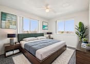 Thumbnail 8 of 23 - A bedroom with a bed, nightstand, and a ceiling fan.