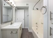 Thumbnail 12 of 36 - a bathroom with a sink and a shower and a mirror
