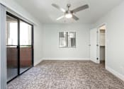 Thumbnail 8 of 36 - an empty living room with a ceiling fan and a glass door
