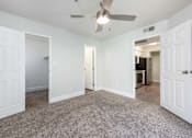 Thumbnail 10 of 36 - an empty living room with white doors and a ceiling fan
