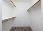 Thumbnail 11 of 36 - a walk in closet in a white room with white walls and a carpet