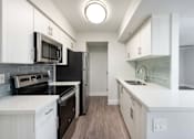 Thumbnail 6 of 36 - an empty kitchen with white cabinets and a black stove and refrigerator