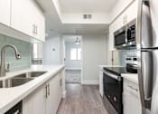 Thumbnail 7 of 36 - a kitchen with white cabinets and a sink and a refrigerator