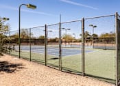 Thumbnail 34 of 36 - a tennis court with a chain link fence and a lamp post