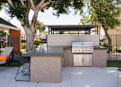 Thumbnail 26 of 36 - the outdoor kitchen has a grill and a table and chairs