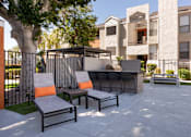 Thumbnail 27 of 36 - a patio with a bar and chairs in front of an apartment building