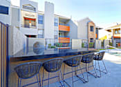 Thumbnail 29 of 36 - a patio with a table and chairs in front of some apartments