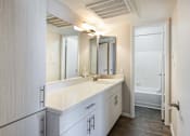 Thumbnail 8 of 25 - a bathroom with a sink and a mirror and a shower