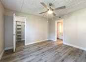 Thumbnail 9 of 25 - an empty living room with a ceiling fan and a closet