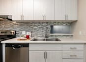 Thumbnail 6 of 25 - a kitchen with white cabinets and a stainless steel sink