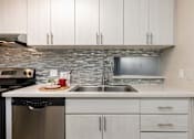 Thumbnail 10 of 25 - a kitchen with white cabinets and a stainless steel sink