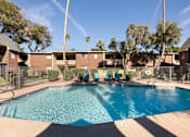 Thumbnail 13 of 25 - a swimming pool with chairs in front of a building
