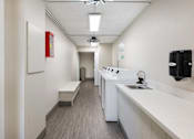 Thumbnail 24 of 25 - a long white room with a sink and a counter top