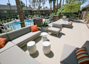 Thumbnail 14 of 25 - a large patio with couches and tables and a pool