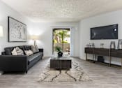 Thumbnail 2 of 23 - a living room with a black couch and a tv