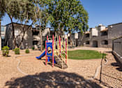 Thumbnail 19 of 23 - a playground with a swing set and slides in front of a building