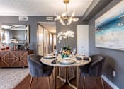 Thumbnail 7 of 31 - A dining room with a round table set for four.