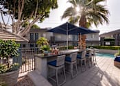 Thumbnail 33 of 34 - A patio with a table and chairs under a blue canopy.