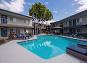 Thumbnail 1 of 34 - A swimming pool surrounded by lounge chairs and trees.