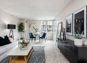 Thumbnail 6 of 35 - a living room with a white couch and a table and chairs