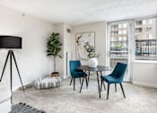 Thumbnail 7 of 35 - a living room with a table and chairs and a window