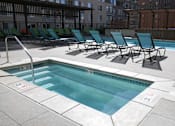 Thumbnail 18 of 35 - the pool and chaise lounge chairs in the pool area of an apartment building