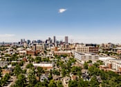 Thumbnail 18 of 18 - A cityscape with a mix of residential and commercial buildings under a clear sky.