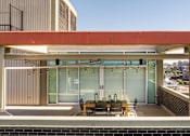 Thumbnail 13 of 18 - A modern building with a red and white exterior and a glass wall.