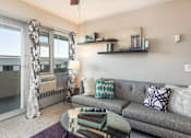 Thumbnail 3 of 18 - A living room with a grey couch and a glass table.